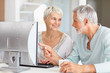 Photo: Senior man helping wife to use computer Senior man helping wife to use computer