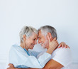 Charming retired couple with their heads together,