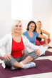 Women sitting cross-legged on mat
