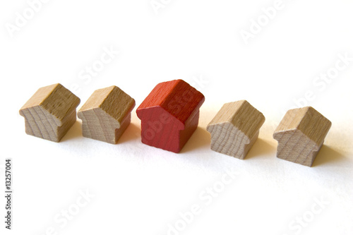 Photo: Five wooden houses from “Monopoly” on white background Five wooden houses from “Monopoly” on white background