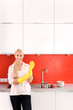Woman wearing rubber gloves standing in kitchen