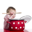 Toddler pretending to cook with a big red pot.