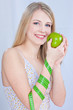 Pretty blond girl with apple and measuring tape