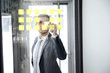 geschäftsmann arbeitet hinter scheibe mit post it