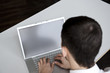 mann sitzt und arbeitet an monitor eines notebooks
