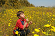 child blowing a dandelion