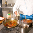 Chef hands with frying pan on professional kitchen
