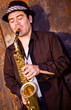 saxaphonist plays outdoors against an industrail backdrop saxaphonist plays outdoors against an industrail backdrop