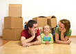 Happy couple with a kid in their new home