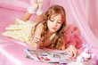 Foto: Beautiful little girl reading magazine Beautiful little girl reading magazine
