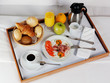 Breakfast tray laying on white bed in upscale hotel