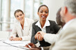 Happy business woman being congratulated by a senior person