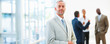 Senior mature business man with other staff at the back