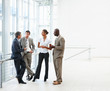Image of four business people discussing at the hallway