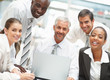 Confident business team working together on a laptop