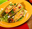 A plate of freshly prepared beef tacos, with tomato and cheese A plate of freshly prepared beef tacos, with tomato and cheese