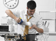 business man in the kitchen cutting an egg with a saw business man in the kitchen cutting an egg with a saw