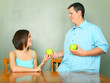 Male Caucasian Giving Green Apple To Young Woman