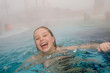 Sophie schwimmt im  beheizten Kurbades im Dunst im Winter