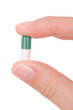 Hand holding a capsule or pill close up Hand holding a capsule or pill close up