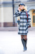 Beautiful young blond in a coat talks on the phone
