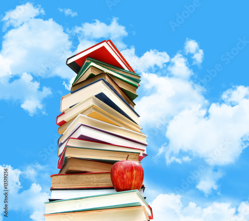 Photo: Pile of books and apple against blue sky Pile of books and apple against blue sky