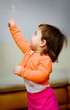 a little girl plays with a bubble