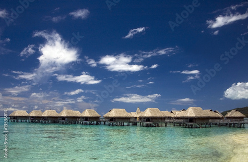 Photo: beach bungalows at tropic lagoon under blue sky beach bungalows at tropic lagoon under blue sky