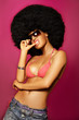 Beautiful woman with huge afro haircut on pink