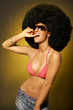 Beautiful woman with huge afro haircut on yellow