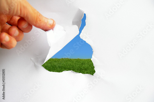 Photo: blue sky and green grass behind torn paper blue sky and green grass behind torn paper