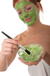 Body care series - Young woman applying facial mask