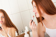 Body care series - Beautiful red hair woman applying lipstick