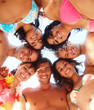 Happy friends standing a circle at the beach