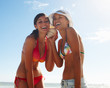 Teenage girls in bikini holding a conch shell