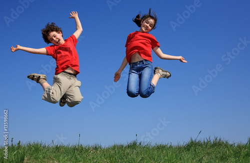 Photo: Kids jumping, running against blue sky Kids jumping, running against blue sky