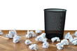 Empty wastepaper basket surrounded by crumpled documents Empty wastepaper basket surrounded by crumpled documents