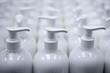 White plastic soap bottles in rows assembly line White plastic soap bottles in rows assembly line