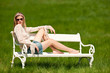 Attractive young woman sitting on white bench