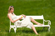 Young woman in white dress holding dandelion