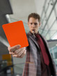 Man in suit holding penalty red card