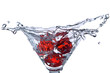 Red Dice falling in the martini glass with splashes of water