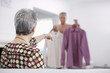 Senior woman pointing at shirts that man is deciding between