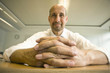Photo: Close-up of clasped hands of mature man sitting at table Close-up of clasped hands of mature man sitting at table