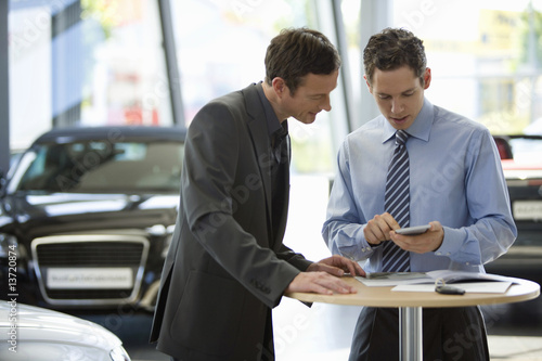 Photo: Man talking to car salesman Man talking to car salesman