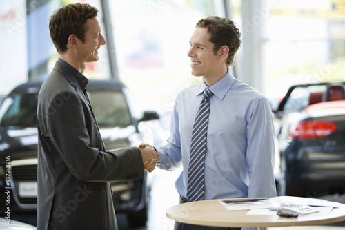 Photo: Man talking to car salesman Man talking to car salesman
