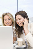 Photo: Two women sitting at outdoor caf looking at computer, Stuttgart, Baden-Wurttemberg, Germany Two women sitting at outdoor caf looking at computer, Stuttgart, Baden-Wurttemberg, Germany