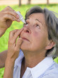 Senior woman using eye drops