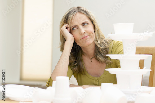 Photo: Mature woman sitting in front of disposable tableware, Den Haag, Netherlands Mature woman sitting in front of disposable tableware, Den Haag, Netherlands