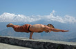 Yoga in Himalayas. One-hand standing.